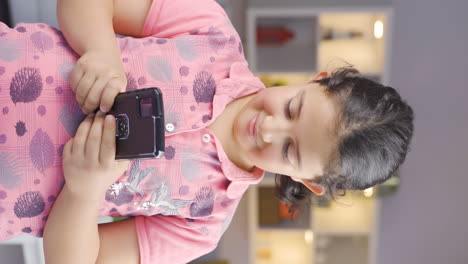 Vertical-video-of-Happy-girl-child-texting-on-the-phone.-Smiling.